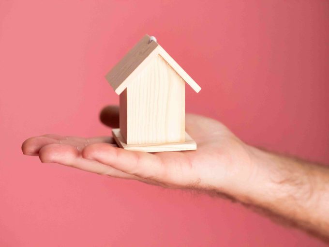 mano che tiene casetta di legno per rappresentare nuda proprietà